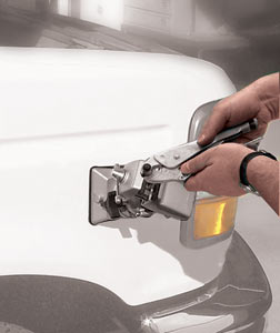 Working on a vise secured item as the PanaVise 381 vacuum base holding tool is attached to a car's exterior