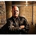 Doug M. Cummings, author of the Reno McCarthy novels, striving to look like a two-fisted author with a scary background and tough guy leather coat.