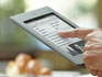 Kindle Touch e-reader: device held in one hand, with finger on touchscreen