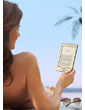 Kindle e-reader: reads like real paper, even in bright sunlight, as shown by woman reading a Kindle by the pool