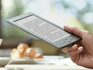Kindle e-reader: device in hand, reading at cafe