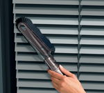 Using the stubborn dirt brush tool to clean a dusty blind