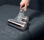 Mini turbine head cleaning a sofa cushion