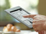 Liseuse Kindle Touch 3G : appareil tenu en main, avec un doigt sur l'�cran tactile