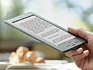 El e-reader Kindle sostenido en la mano mientras se toma un caf�